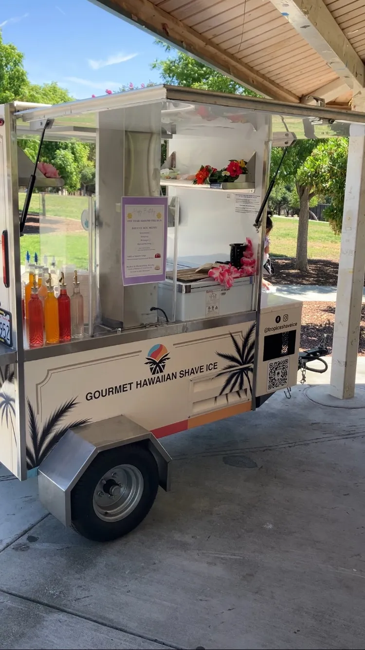 Front view of the Tropics Shave Ice branded mobile cart
